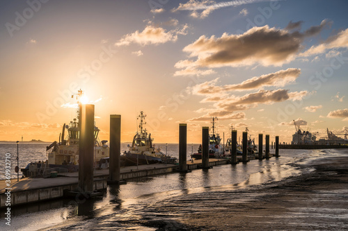 Schiffe an einem Anleger in Bremerhaven bei malerischem Sonnenuntergang über der Weser
