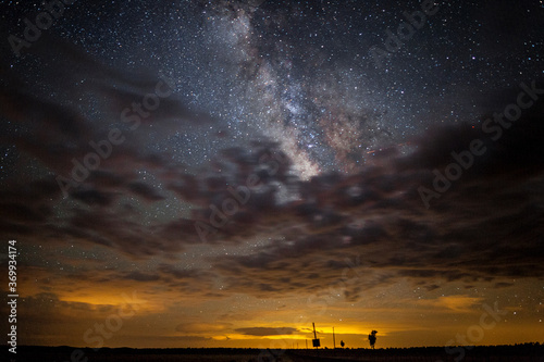 Fototapeta Naklejka Na Ścianę i Meble -  The Milky Way stars partially obscured by a layer of clouds in the night sky