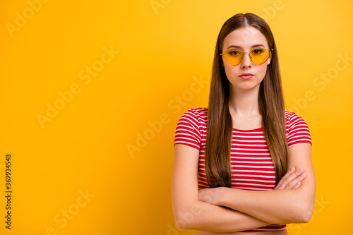 Photo of charming gorgeous self-assured young girl folded arms almost angry dissatisfied disagree canceled pool party wear sun specs striped white red shirt vivid yellow color background