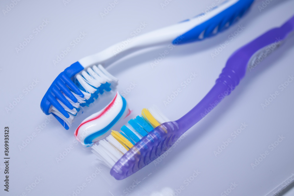 two toothbrushes on a white background next to the toothpaste. healthy and clean teeth concept, dentistry. High quality photo two toothbrushes on a white background next to the toothpaste. healthy and clean teeth concept, dentistry. High quality photo
