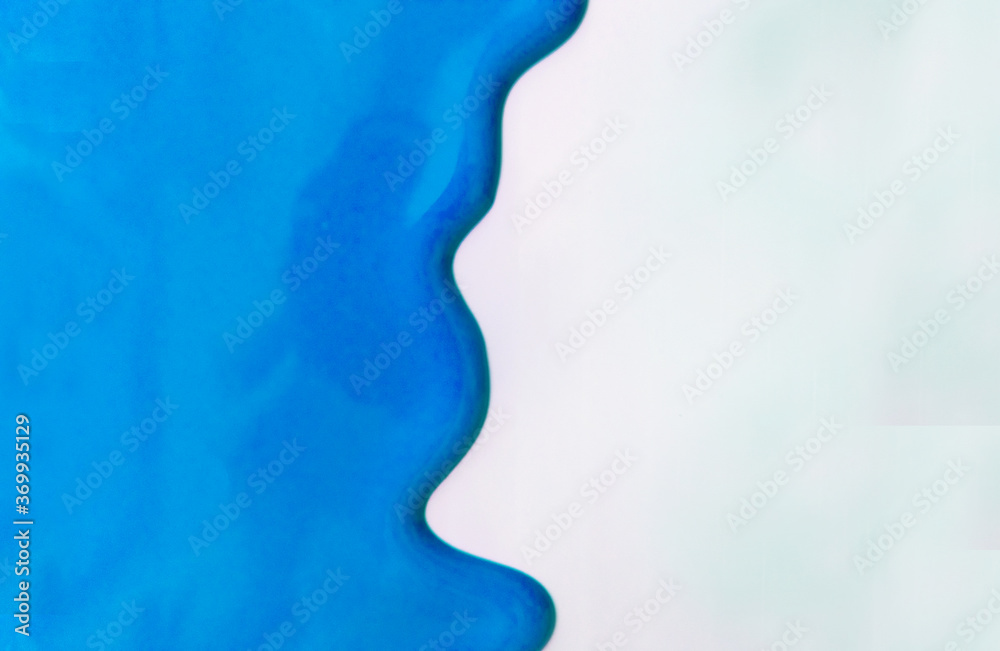 Light blue paint spreads on a white background. Copy space.