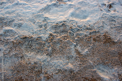 Salty sea shore.Texture of sea salt farm is the place with so much sea-salt production in the country,or salt evaporation plant these ponds have vivid colors. photo