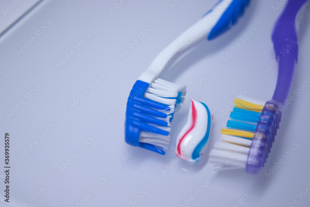 two toothbrushes on a white background next to the toothpaste. healthy and clean teeth concept, dentistry. High quality photo two toothbrushes on a white background next to the toothpaste. healthy and clean teeth concept, dentistry. High quality photo