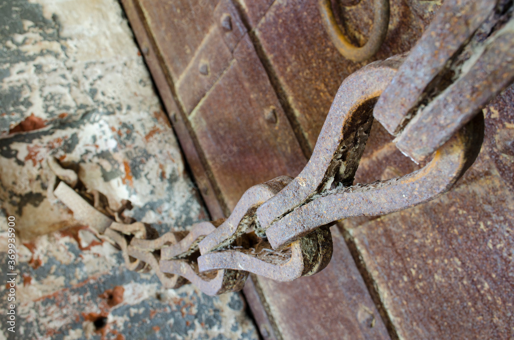 Old rusty chain and massive wrought iron doors
