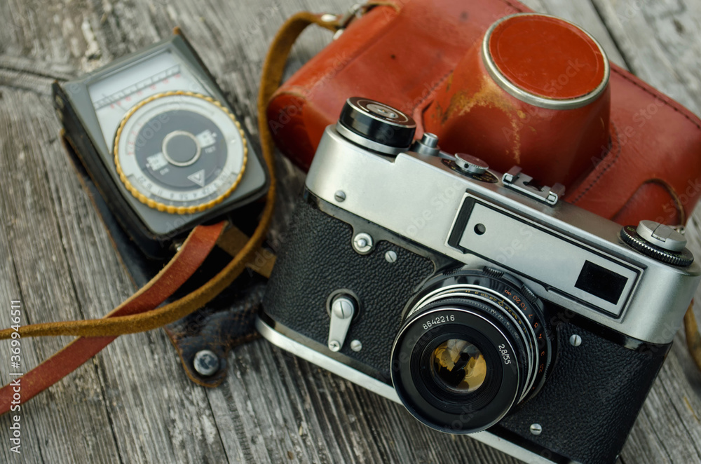 old camera in a leather case and a light meter