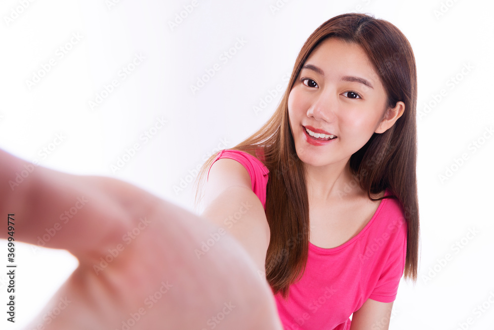 Face of cheerful young woman wear pink t-shirt with white teeth holding hand making selfie against while standing over isolated white background. Enjoy lovely girl taking photographing herself. Face of cheerful young woman wear pink t-shirt with white teeth holding hand making selfie against while standing over isolated white background. Enjoy lovely girl taking photographing herself.