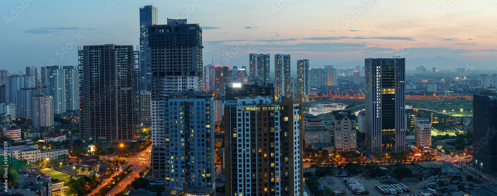 Fototapeta premium Cityscape of Hanoi skyline in Cau Giay district by Cau Giay park during sunset time in Hanoi city, Vietnam