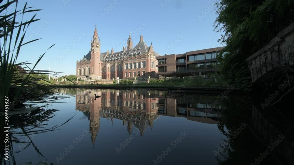 Peace Palace, one of the most visited monument in The Hague, reflected on the calm water of the rose garden and its pond, Netherlands Peace Palace, one of the most visited monument in The Hague, reflected on the calm water of the rose garden and its pond, Netherlands