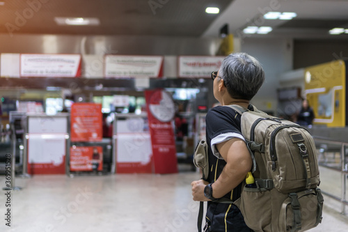 Covid-19 pandemic impact to Traveler was cancel flight for stop prevent COVID-19 virus disease, state quarantine concept, Asian senior woman tourist backpack in empty airport to avoid world lockdown