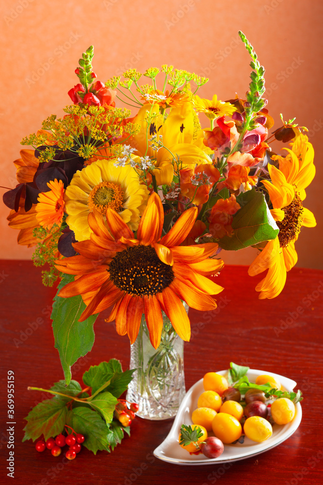 Autumn still life with bouquet of flowers and berries