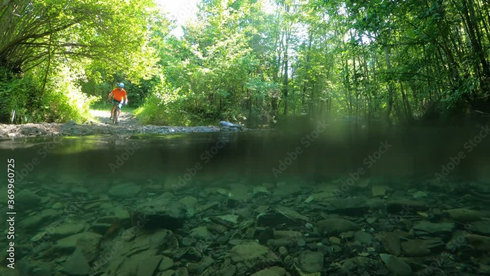 custom made wallpaper toronto digitalMan on bike crossing mountain river with water splashes slow motion.