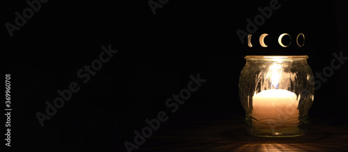 All Saints Day candle. White grave candle on dark background photo