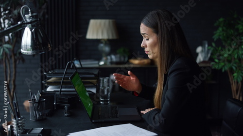 Disappointed businesswoman video chatting online with business partner in office
