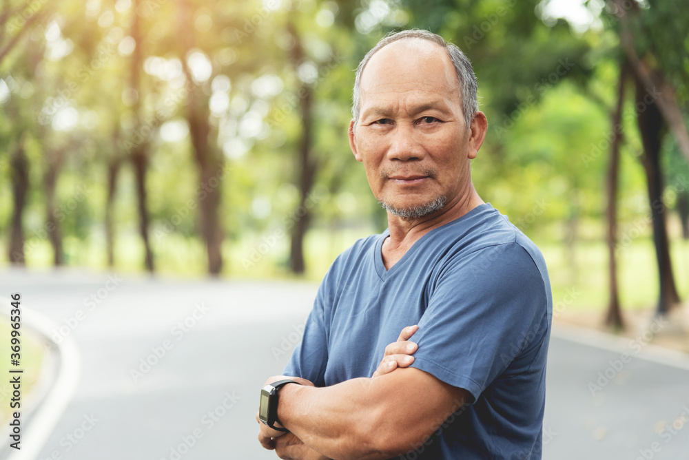 Portrait of Asian Senior man smiling with arms crossed at park outdoor Portrait of Asian Senior man smiling with arms crossed at park outdoor