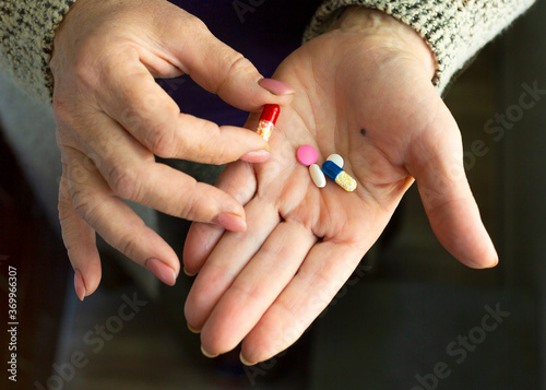 Close up photo of a drugs in old woman s hands.