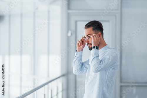 Young handsome man in formal clothes indoors in the office at daytime