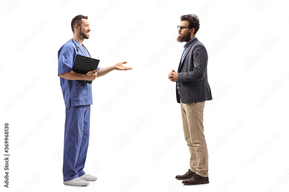 Full length profile shot of a medical worker explaining and gesturing with hands and standing with a bearded man Full length profile shot of a medical worker explaining and gesturing with hands and standing with a bearded man