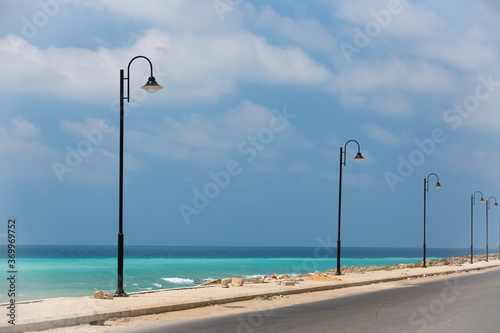 The road along the turquoise sea. Lebanese Mediterranean coastline. Street lights on the waterfront in Lebanon. Sea water of amazing color. The coastland between Sidon and Beirut