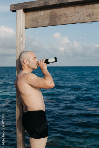 Man Drinking Beer on Pier