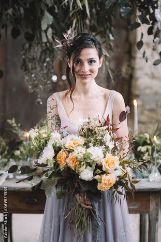 Bride with bouquet near wedding table