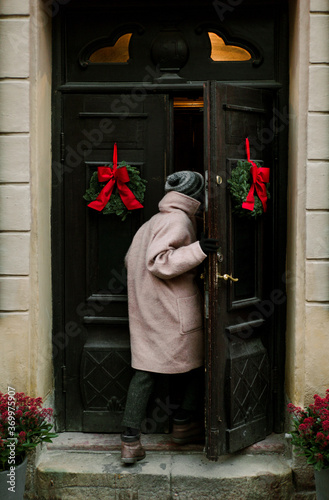 The girl enters the building through the Doors with Christmas decorations photo