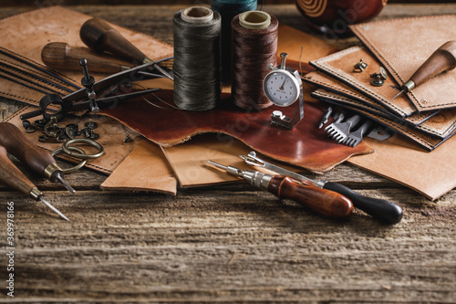 Leather craft tools on old wood table. Leather craft workshop.