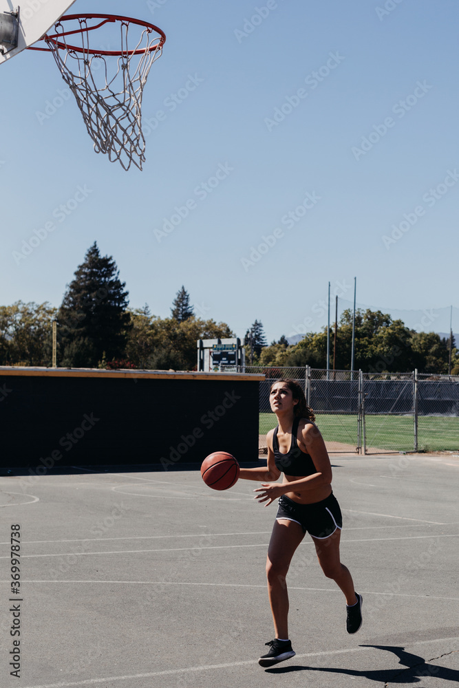 Woman Shooting Hoops on Basketball Court Woman Shooting Hoops on Basketball Court