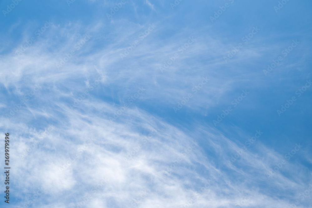 Cloudy sky. White cirrus clouds fly across the blue sky. Natural landscape background.