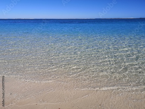 Tranquil water s edge on a white sand beach in Australia