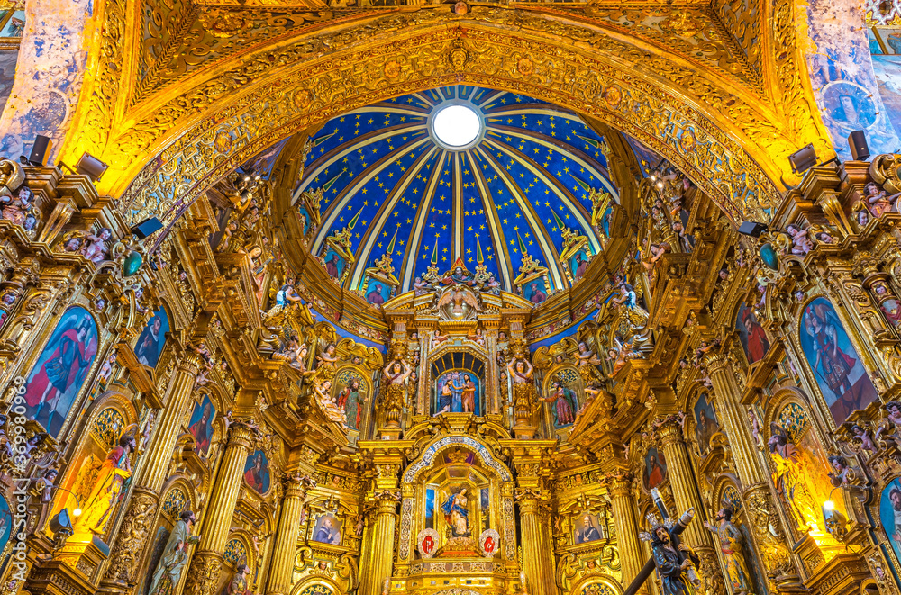 Baroque interior of the San Francisco church with gold leaf decorations and blue dome, Quito, Ecuador.