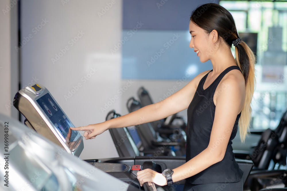 Asian women are exercising in the GYM to lose weight and keep their bodies in good shape.