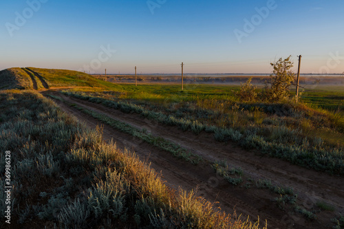 Rustic landscape - the path that goes straight on the damb between village fields