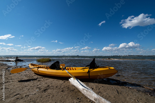 Yellow kayak on the lake shore in the city limits on a Sunny summer day