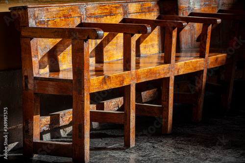 Late afternoon sun shines on a 16th century wooden bench in the convent of Santo Domingo in Cusco  Peru.