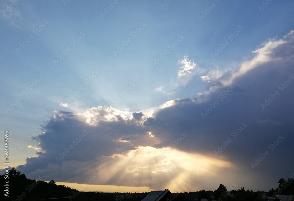 Fototapeta premium sunset sky with blue shadows and bright sun rays 
