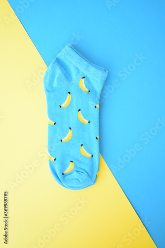 Blue fashionable socks with banana pattern print on blue and yellow background
