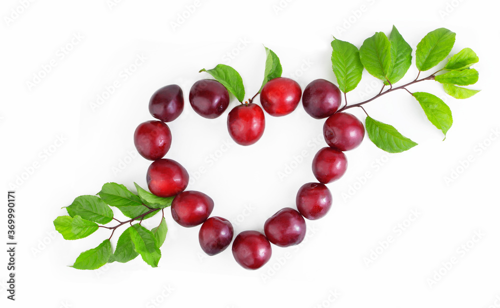 Obraz premium Fresh plums in the shape of a heart isolated on a white background. Valentine's day concept. Banner, frame. Copy space.