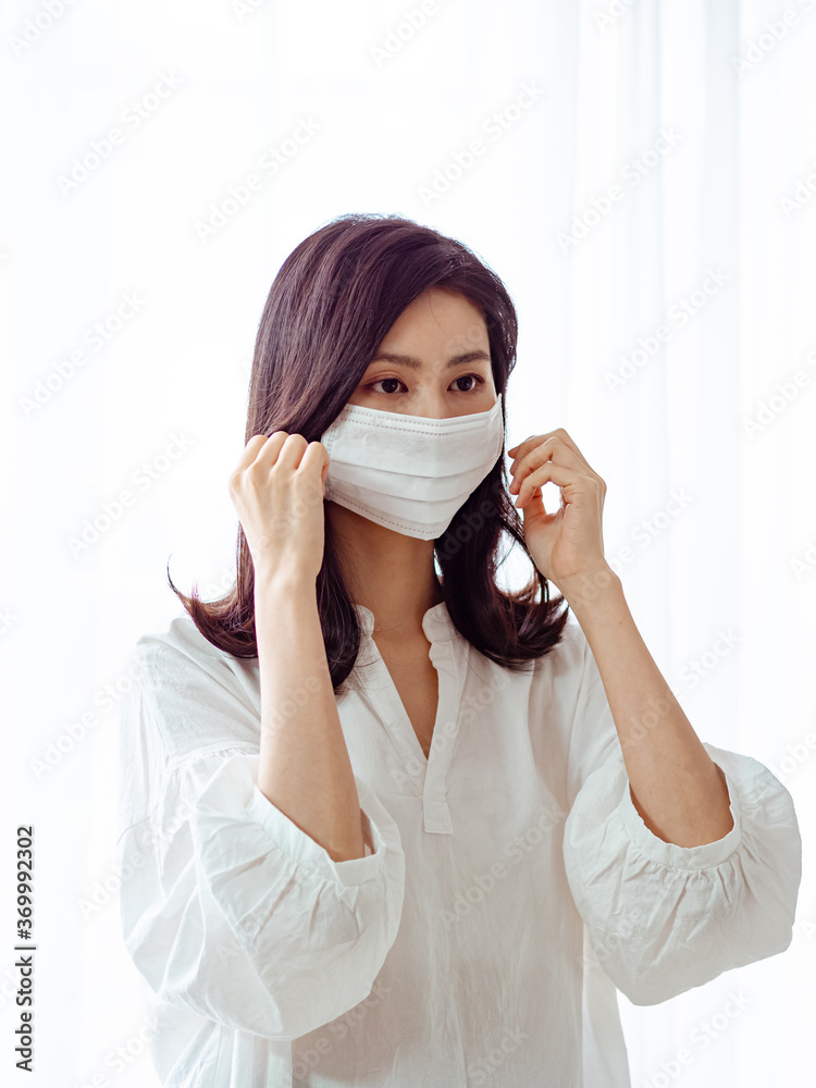 Young asian woman wearing Surgical mask at home Young asian woman wearing Surgical mask at home