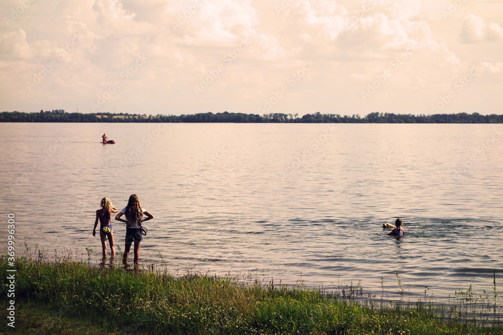 Girls are playing and swimming in the lake during the holidays a