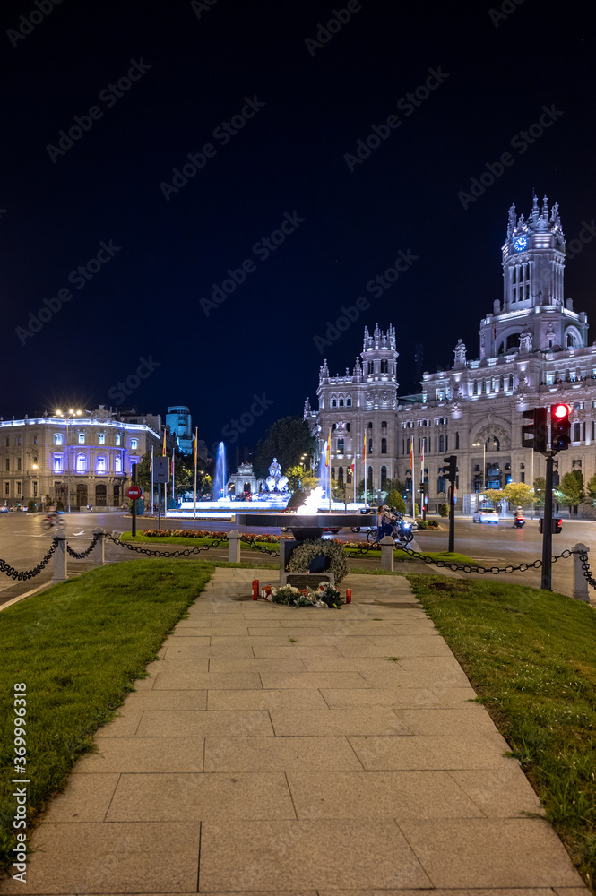 Naklejka premium Monument in tribute to the victims of Covid-19 consisting of an eternal flame in front of the Plaza de Cibeles and the city hall in Madrid, Spain