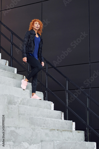 Young european redhead woman have walk on the stairs outdoors