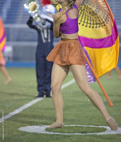 Marching band performers. Flag twirlers and dancers in a band competition on a field photo