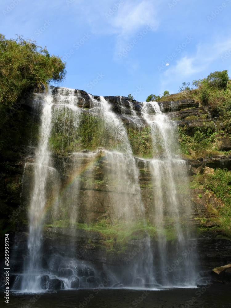 waterfall over a lake with a rainbow