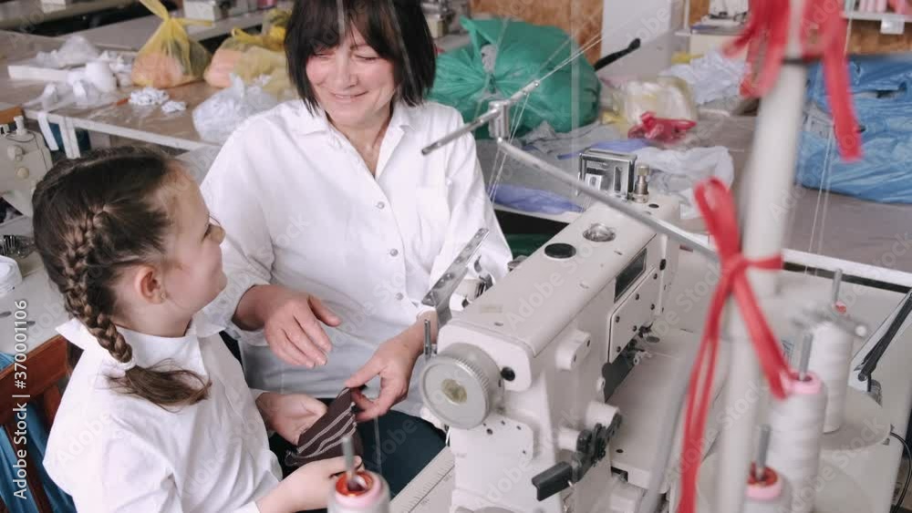 Grandmother with granddaughter at the factory. Family with a fabric.