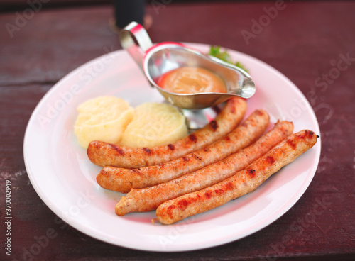 dish with bavarian sausages and mashed potatoes with sauces