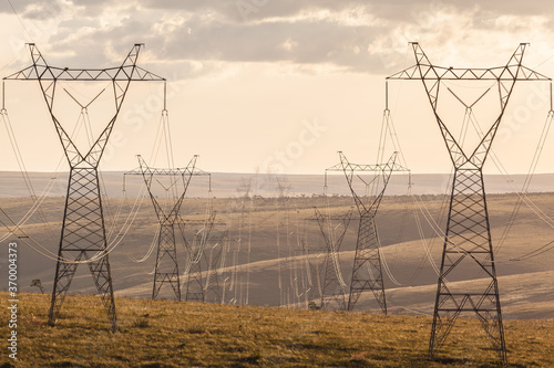High voltage post. High-voltage transmission lines at sunset.