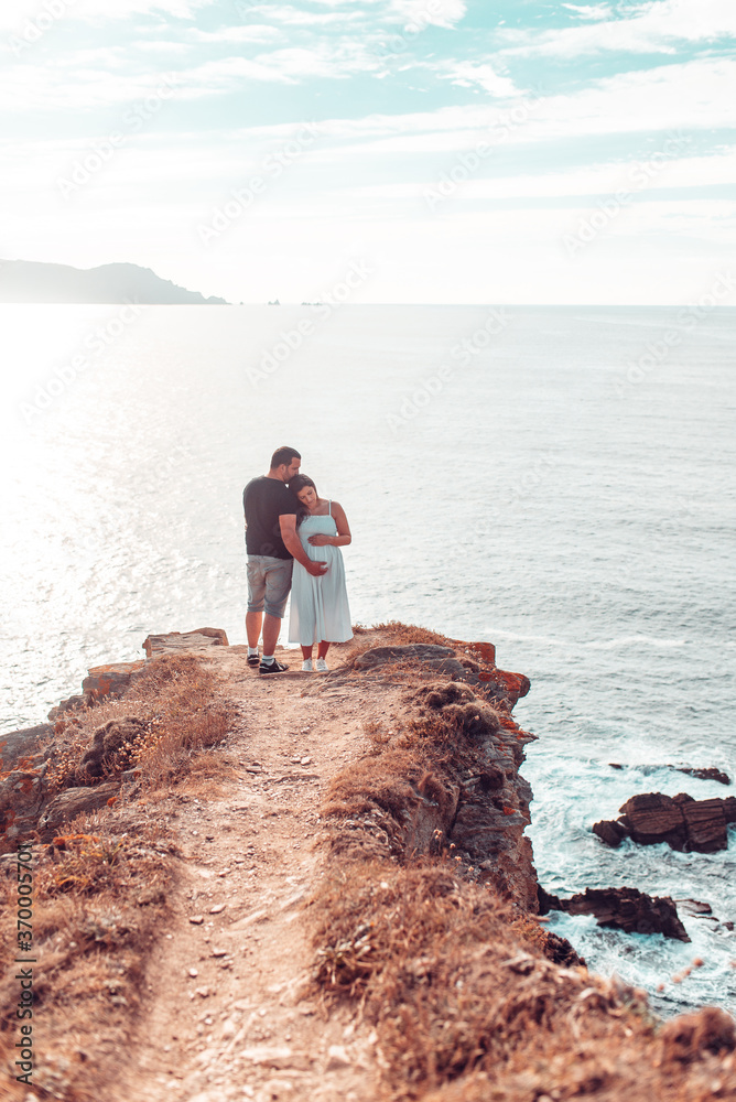 Pregnant couple on top of a cliff
