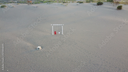 Aerial view of mother and child playing on the sand dune photo