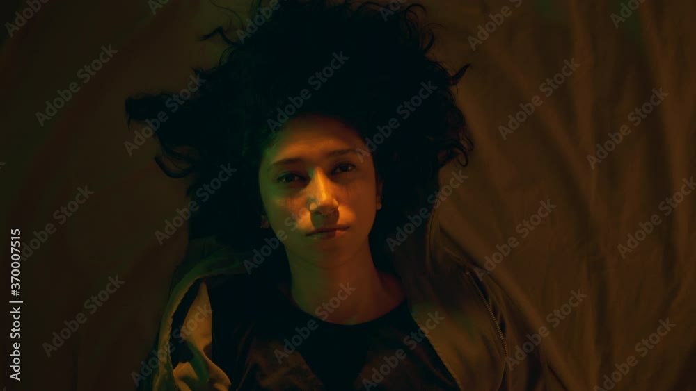 Close-up of a black haired girl with a deep gaze who is lying on the bed. Dolly shot Close-up of a black haired girl with a deep gaze who is lying on the bed. Dolly shot