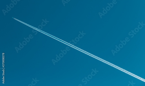 trail of a flying plane in a clear sky